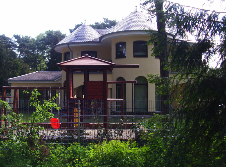 Runde Kegeltürme an der mediterranen Villa mit Mönch und Nonnen-Dachdeckung. Mediterran bauen Einfamilienhaus mit Doppelgarage und südländischem Flair.