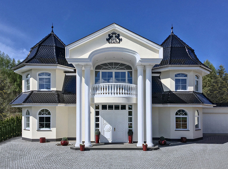 Energieeffiziente Stadtvilla mit doppelflügelige Haustür, mit unterschiedlichen Bögen gestalteten Sprossen-Fenster.