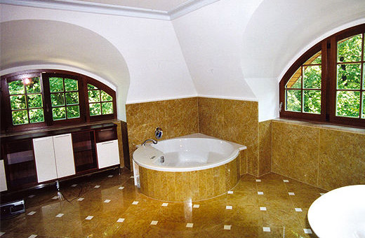 Licht durchfluteter gemütlicher Badezimmer mit runden Sprossen-Holzfenstern.