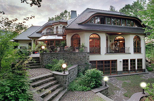 Massivhaus Grunewald als Landhausvilla am See mit Schwimmhalle im Souterrain. Ein Einfamilienhaus als Winkelhaus.